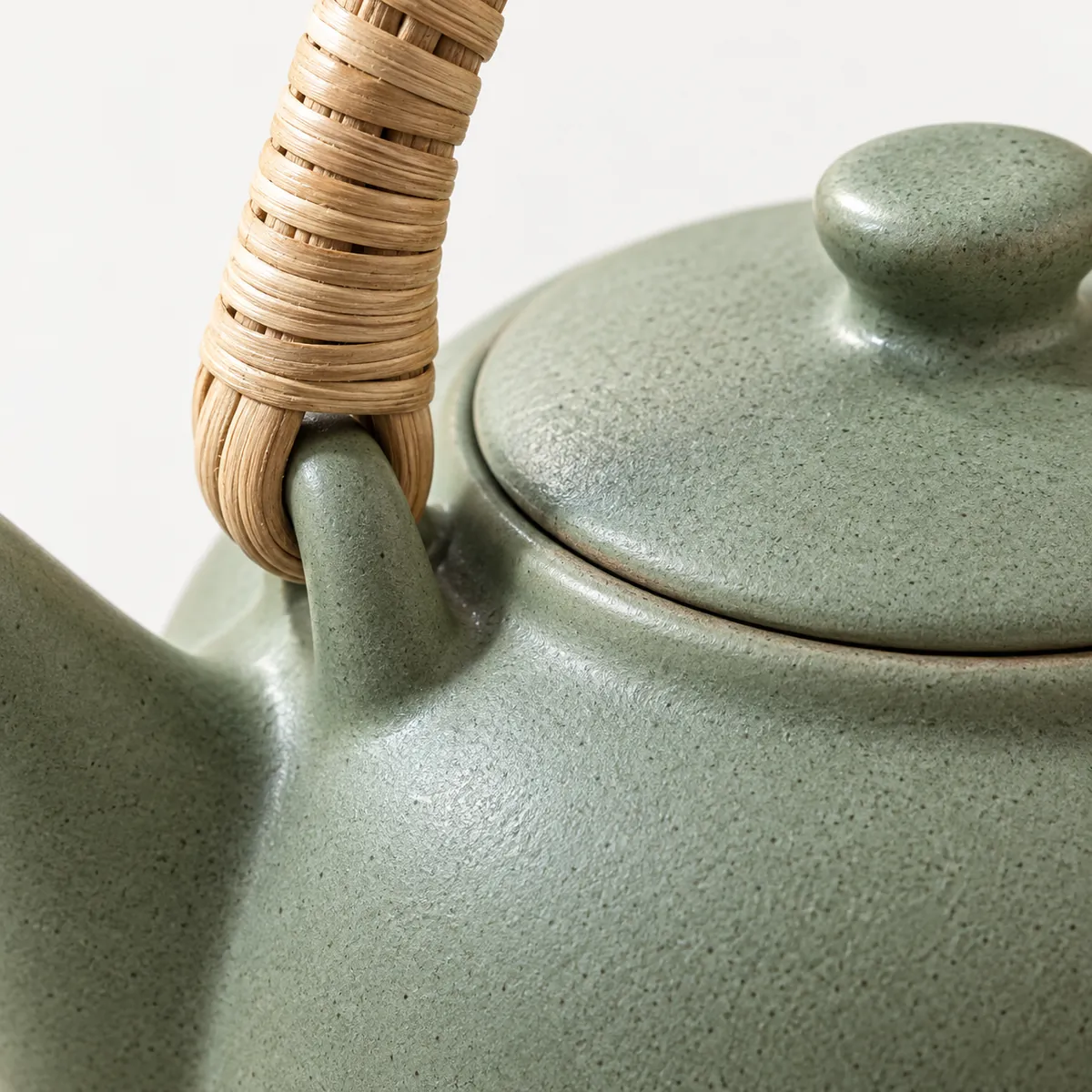 Close-up of the rattan wrap where the handle meets the teapot's shoulder