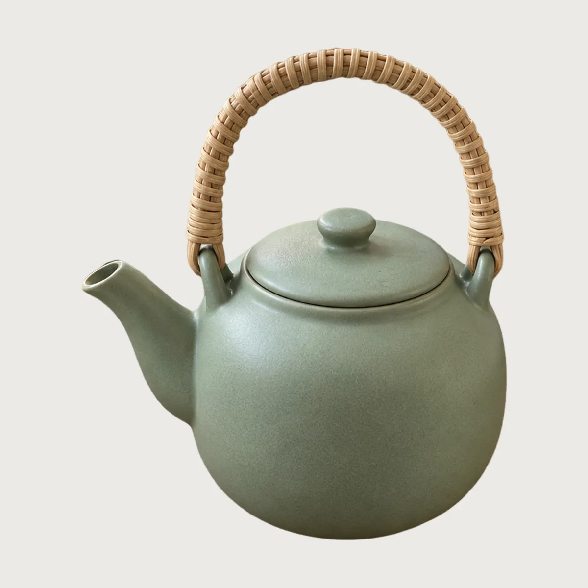 The same teapot on a light warm-grey background instead of white